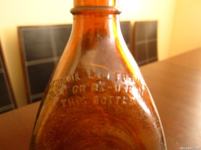 Текст: «Federal Law forbids sale or re-use of this bottle»